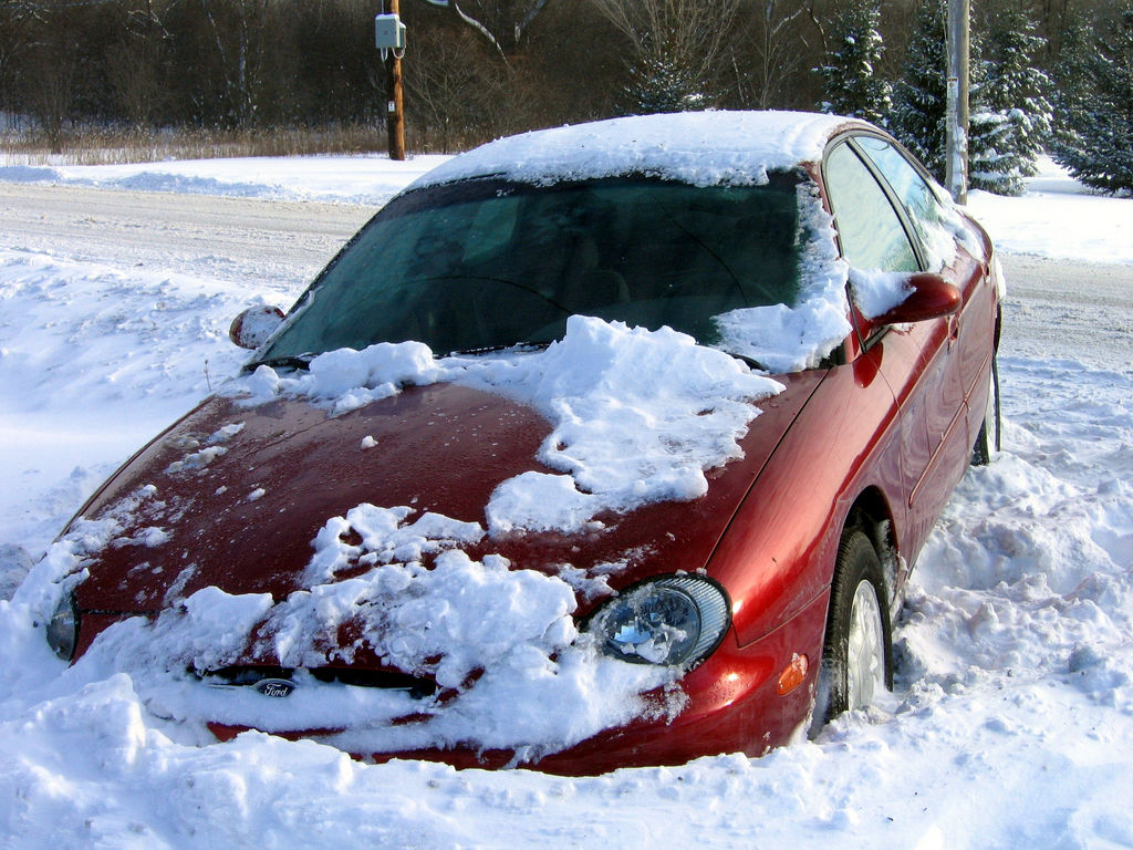 photograph of a car stuck in a snow bank